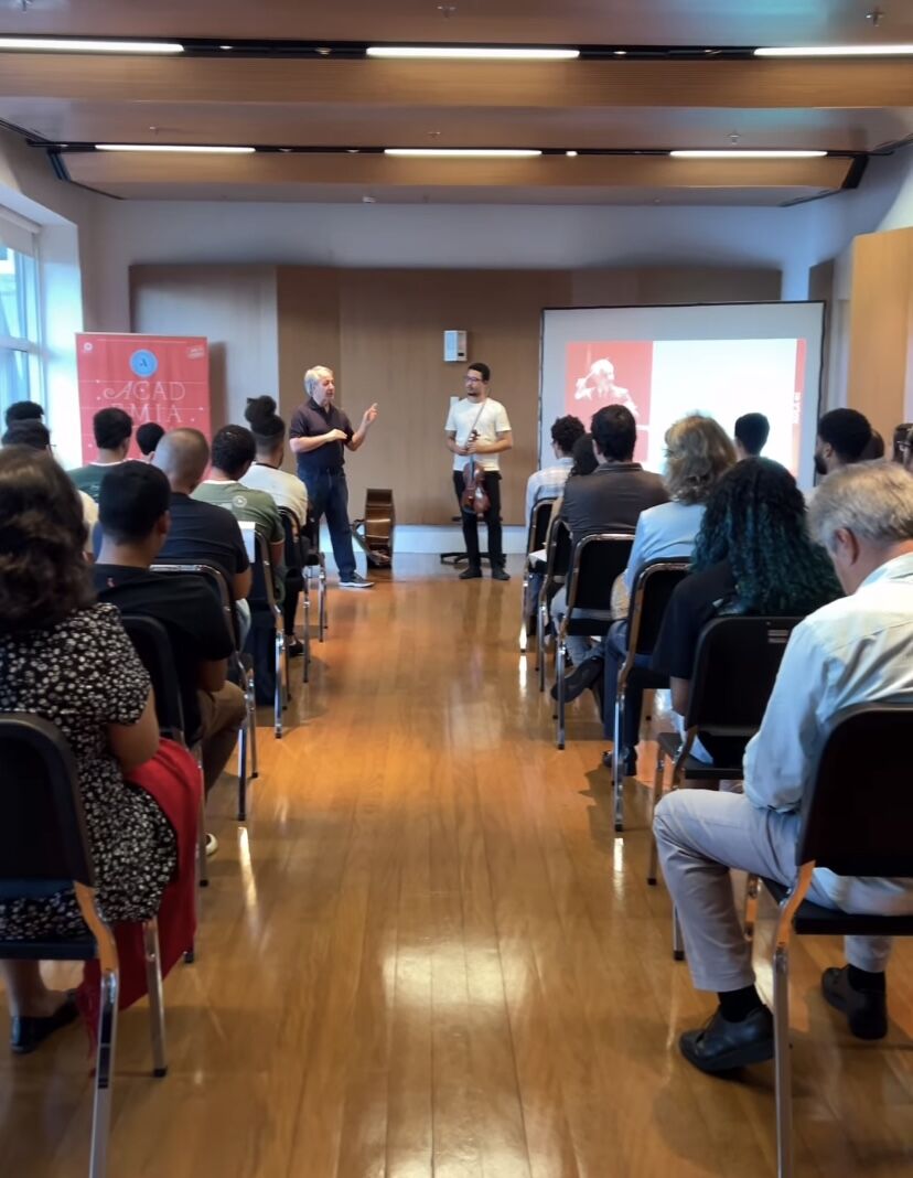 André com a viola diante do público em um encontro da Academia