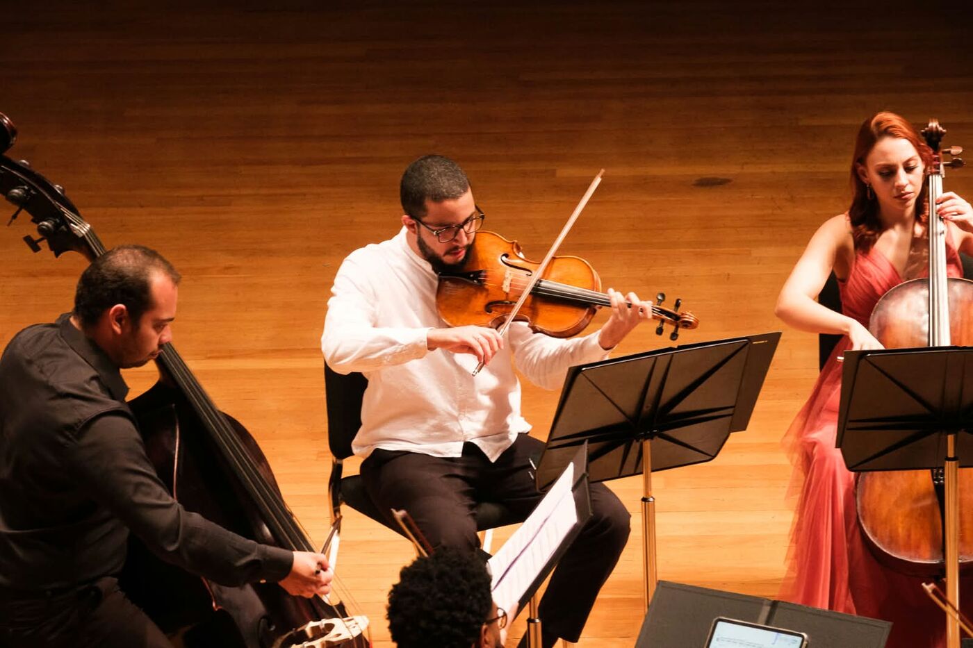 André tocando viola de camisa branca entre contrabaixo e violoncelo