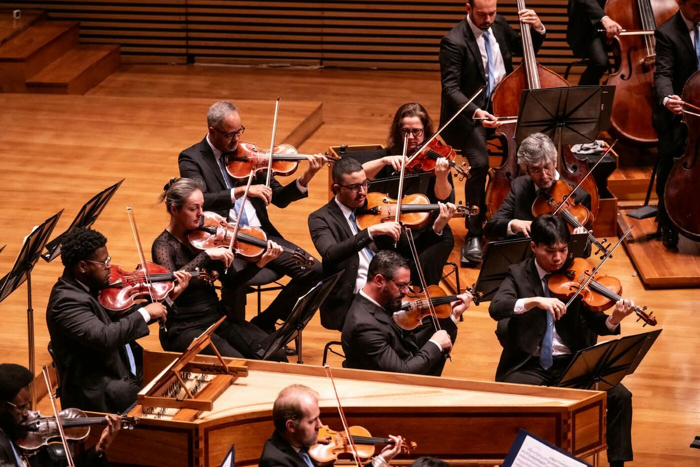 Naipe de violas da orquestra tocando ao lado do cravo